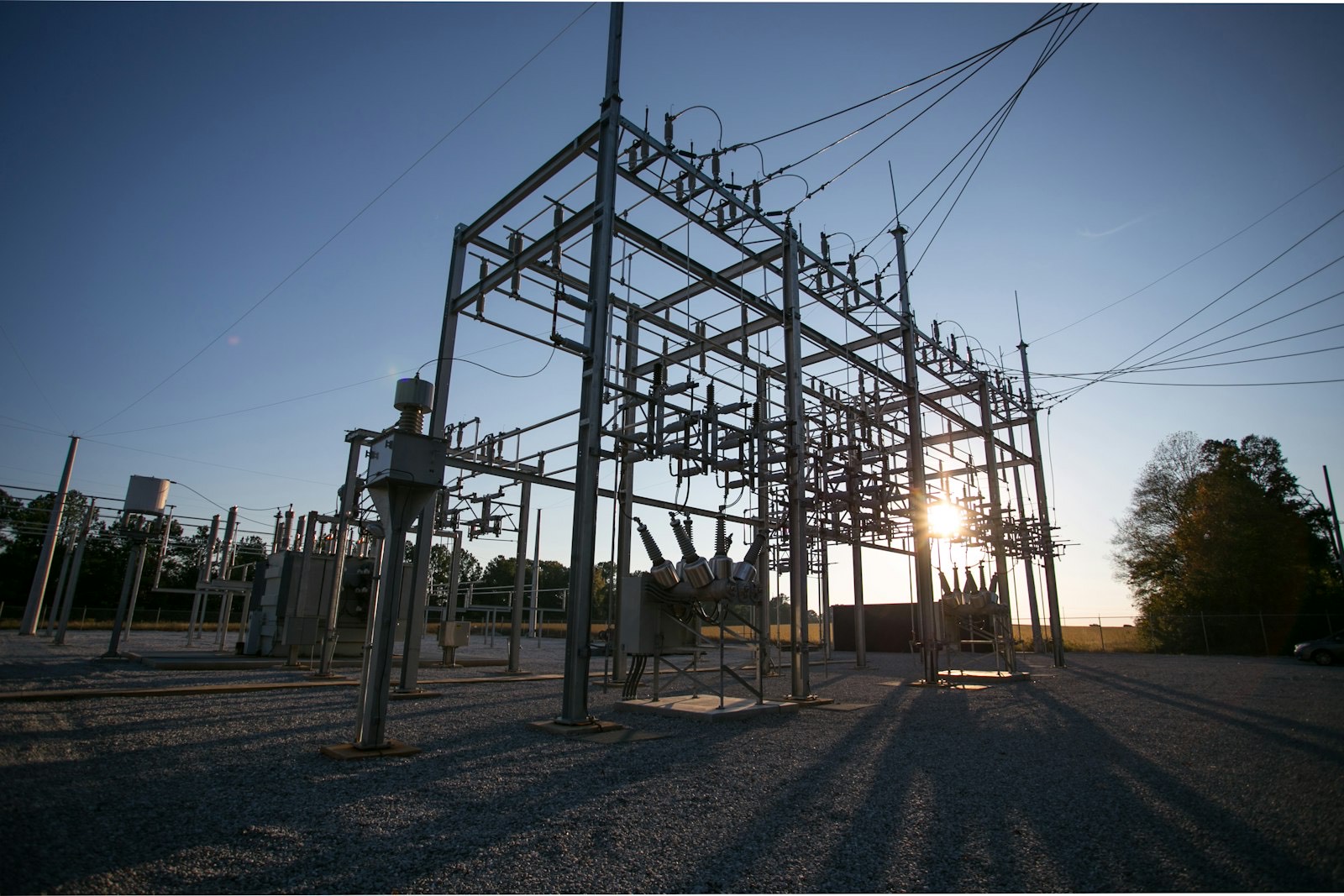 Electrical substation switchyard with the sun flaring through the structure
